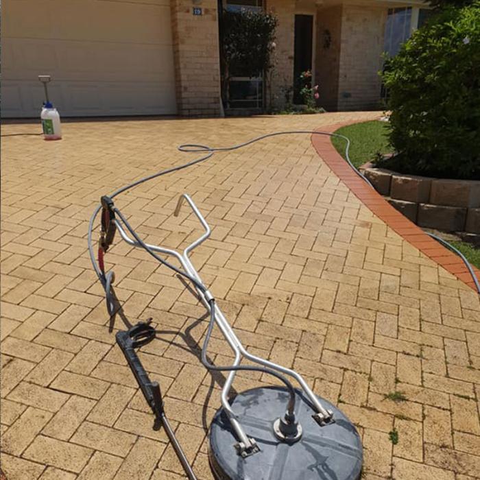 High pressure cleaning machine on driveway half done