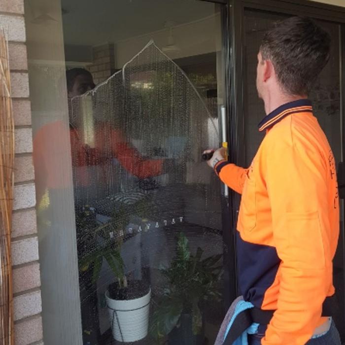 Steve cleaning house windows with squeegee